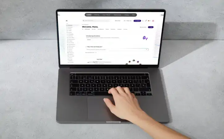 Hands typing on a laptop showing a project dashboard